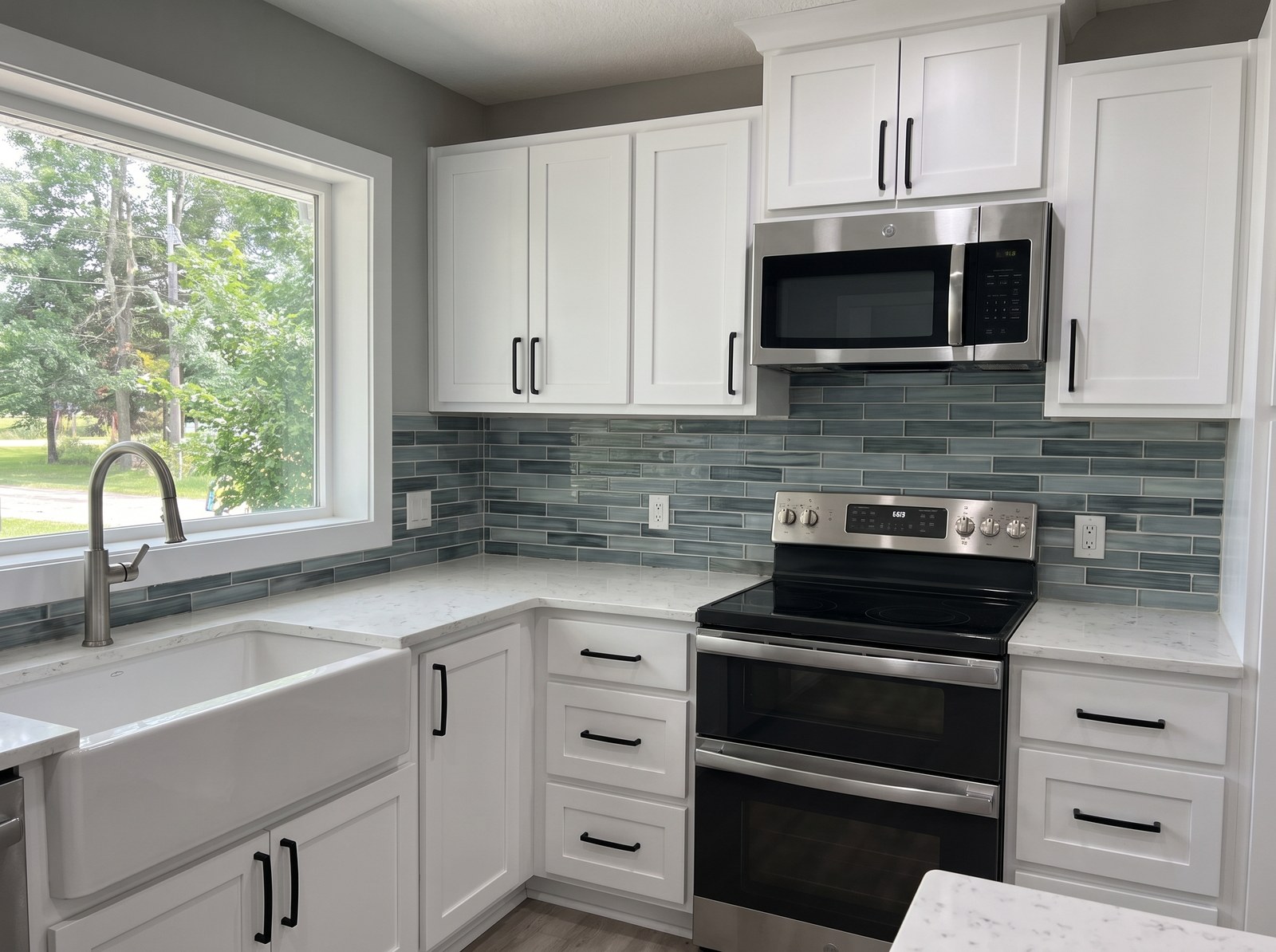 Finished kitchen remodel with new cabinets, counters and tile backsplash